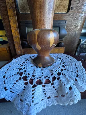 Sale Photo Thumbnail #259: A beautiful vintage hand-turned wooden vase featuring a segmented, inlaid geometric design with contrasting light and dark wood tones. The vase has a flared trumpet top and a bulbous pedestal base. The underside features a green felt ring and is stamped w