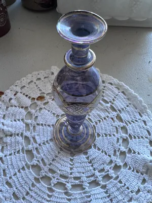 Sale Photo Thumbnail #317: A beautiful vintage bud vase featuring a purple or amethyst-colored glass body with cut-to-clear geometric patterns and elegant gold-toned painted trim bands. The piece has a flared rim, a bulbous body, and a pedestal base. It is in good vintage condition