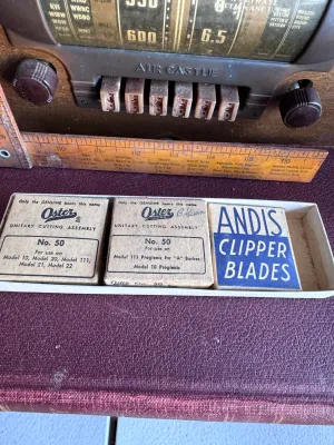 Sale Photo Thumbnail #295: A collection of vintage barber/hair clipper replacement blades in their original cardboard packaging. Includes:
- One Oster Unitary Cutting Assembly No. 50 (for use on Models 10, 20, 111, 21, and 22)
- One Oster Unitary Cutting Assembly No. 50 (for use on