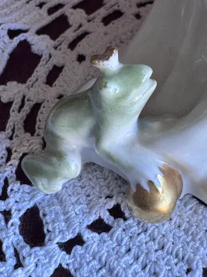 Sale Photo Thumbnail #76: An elegant vintage porcelain figurine depicting the Frog King (Der Froschkönig) fairy tale, featuring a princess with a golden crown looking down at a small green frog with a golden ball. Produced by the renowned maker Rosenthal in Germany. Designed by L
