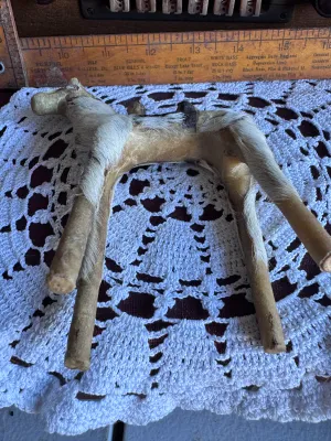 Sale Photo Thumbnail #187: A vintage handmade camel figurine covered in genuine animal fur with leather details forming the saddle and face. This folk art piece stands approximately 6 inches tall and features simple wooden dowel legs. Shows some age-related wear to the leather and 