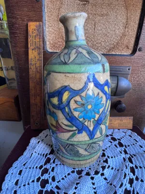 Sale Photo Thumbnail #71: An antique hand-painted earthenware pottery vase or bottle, featuring traditional floral and foliate motifs in vibrant blue, green, yellow, and red glazes over a cream slip ground. The piece exhibits a heavily crackled glaze texture throughout, characteri