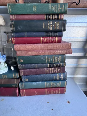 Sale Photo Thumbnail #171: A collection of 17 vintage medical and dental textbooks, primarily focusing on dentistry, oral surgery, and pathology. The hardback volumes feature classic cloth-bound covers in deep greens, blues, and burgundies with gilt lettering on the spines. Notable