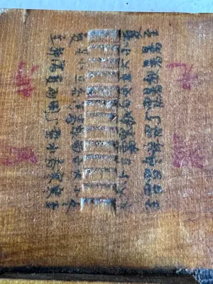 Sale Photo Thumbnail #55: An antique Chinese folding pocket sundial and compass (diptych style) crafted from wood. Features hand-painted Chinese characters, a central compass with a glass cover, and a folding metal gnomon on a hinged wooden plate. The underside and inner surfaces 