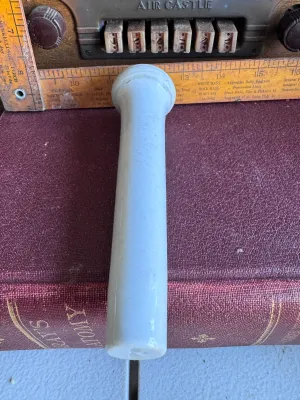 Sale Photo Thumbnail #286: A vintage white glazed porcelain pestle, likely manufactured by Coors Porcelain Company (Golden, Colorado) for laboratory or apothecary use. The piece features a smooth glazed handle and a rounded, unglazed grinding end. It measures approximately 7 inches
