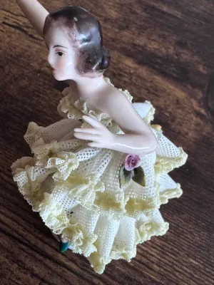 Sale Photo Thumbnail #88: A vintage Capodimonte porcelain figurine depicting a graceful ballerina in a delicate, multi-layered yellow and white porcelain lace tutu. The figure features hand-painted details, including a green bodice, a pink rose accent on the skirt, and gold gilt h