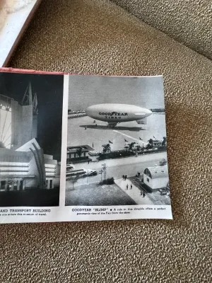 Sale Photo Thumbnail #161: An authentic 1934 souvenir book from the Chicago World's Fair, titled 'A Century of Progress'. This spiral-bound booklet features a textured pink cover with gold-embossed lettering and a central gold seal. Inside, it contains black-and-white photographic 