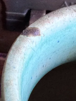 Sale Photo Thumbnail #49: A vintage art pottery vase from Weller Pottery, featuring a matte glaze with a stylized flame or leaf pattern in shades of blue, tan, and light green. Made in the USA. Measures approximately 6 inches tall. The underside shows hand-incised markings. Condit