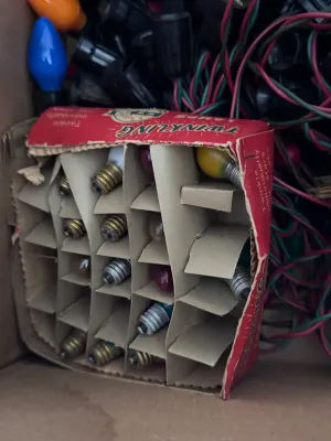 Sale Photo Thumbnail #116: A large estate collection of vintage Christmas lighting. Includes multiple green and red/pink insulated wire light strings with black sockets, a vintage red cardboard box of 'Twinkling Lamps' by World Wide, and a large assortment of loose ceramic and pain