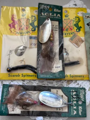 Sale Photo Thumbnail #321: A collection of vintage fishing lures in their original packaging. This lot includes:
- Two Mepps Aglia 'Killer' Original French Spinners by Sheldons' Inc. (Antigo, Wisconsin), featuring natural hair dressings.
- One Herter's Mitchell Scarab Spinners card