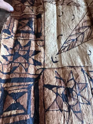 Sale Photo Thumbnail #129: A vintage Pacific Island tapa cloth (siapo / masi), handcrafted from the inner bark of the paper mulberry tree. Features traditional hand-painted geometric patterns, star motifs, and leaf designs in natural brown and black pigments. Shows authentic textur