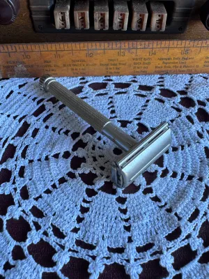 Sale Photo Thumbnail #253: Vintage Lady Gillette double edge safety razor featuring a textured silver-tone handle with the iconic gold-tone starburst design on the collar. Made in the USA by Gillette. This classic twist-to-open (TTO) butterfly razor is in good vintage condition wit