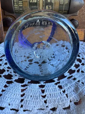 Sale Photo Thumbnail #250: A classic hand-blown drinking glass featuring a vibrant cobalt blue rim and a subtle light blue tint to the body. This rustic tumbler shows characteristic artisanal details, including small trapped air bubbles (seed bubbles) and a rough pontil scar on the
