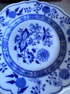 Sale Photo Thumbnail #37: A collection of four blue and white porcelain tea cups with matching saucers in the classic Blue Onion pattern. 

This lot includes:
- Two larger tea cups and saucers marked on the bottom by Hutschenreuther (Selb, Germany).
- Two smaller demitasse-sized c