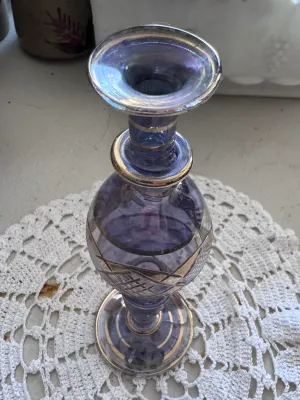 Sale Photo Thumbnail #320: A beautiful vintage bud vase featuring a purple or amethyst-colored glass body with cut-to-clear geometric patterns and elegant gold-toned painted trim bands. The piece has a flared rim, a bulbous body, and a pedestal base. It is in good vintage condition
