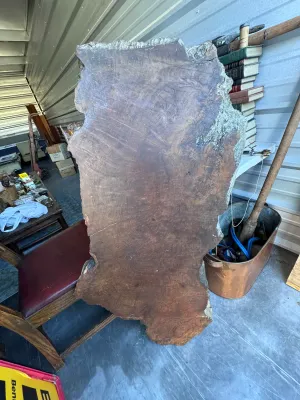 Sale Photo Thumbnail #23: A substantial, thick-cut live edge redwood burl wood slab featuring rich reddish-brown tones, prominent growth rings, and natural textured bark edges. This rustic piece is ideal for a custom coffee table, console top, or wall art. It measures approximatel