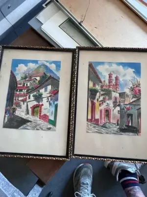 Sale Photo Thumbnail #212: A beautiful pair of original mid-century watercolor paintings depicting vibrant street scenes of Taxco, Mexico. Each piece is signed by the artist 'Max V.' in the lower corner. One painting features a cobblestone street leading toward the iconic Santa Pri