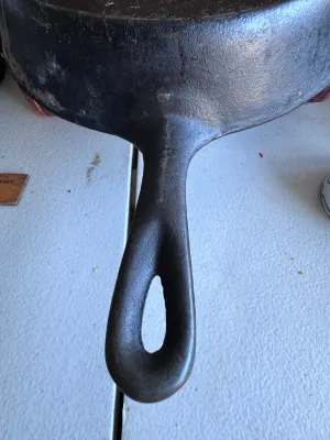 Sale Photo Thumbnail #276: A vintage cast iron skillet featuring the distinctive teardrop-shaped handle hole and number marking characteristic of the Chicago Hardware Foundry (CHF), made in North Chicago, Illinois. The bottom shows a raised number '4' and a diamond mark. The skille