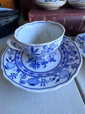 Sale Photo Thumbnail #33: A collection of four blue and white porcelain tea cups with matching saucers in the classic Blue Onion pattern. 

This lot includes:
- Two larger tea cups and saucers marked on the bottom by Hutschenreuther (Selb, Germany).
- Two smaller demitasse-sized c