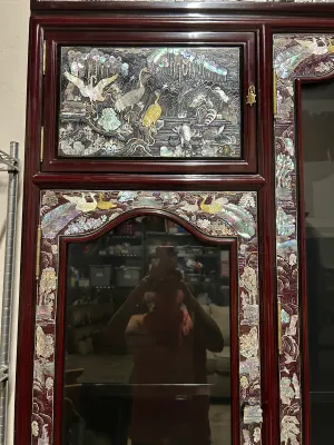Sale Photo Thumbnail #2: Vintage Korean mother-of-pearl lacquer display cabinet featuring intricate, iridescent shell inlay depicting cranes, peacocks, and nature scenes on a dark cherry wood finish.