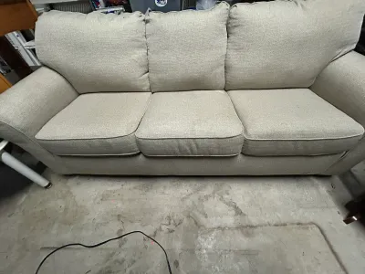 Sale Photo Thumbnail #4: Three-cushion sofa upholstered in a light beige textured woven fabric, featuring rolled arms and loose back cushions.