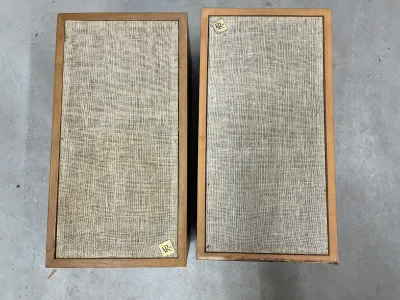 Pair of vintage Acoustic Research AR-4x speakers featuring walnut cabinets and original linen grilles with brass logo badges.