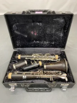 Yamaha wooden clarinet, disassembled and presented in its original black hard-shell carrying case with plush lining.