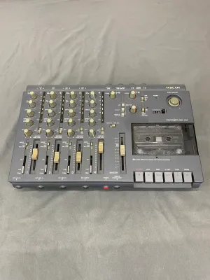 Vintage Tascam Portastudio 414 four-track cassette recorder and mixer, showing some wear and dust from use.