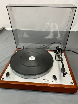 Vintage Thorens TD 166 MkII belt-drive turntable featuring a wooden plinth, silver faceplate, and original dust cover.