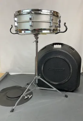 Vintage Ludwig Acrolite snare drum with stand, hard shell carrying case, practice pad, and drum keys.