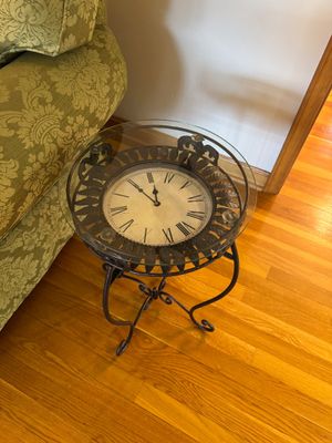 Sale Photo Thumbnail #27: Wrought iron accent table featuring a round glass top over an integrated clock face with Roman numerals.
