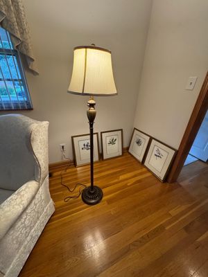 Sale Photo Thumbnail #5: Traditional bronze-finished floor lamp with a bell-shaped fabric shade, shown alongside a set of four framed botanical art prints.