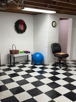 Sale Photo Thumbnail #29: Assorted home gym and office items, including a blue exercise ball, small hand weights on a low plastic table, and a black rolling office chair.