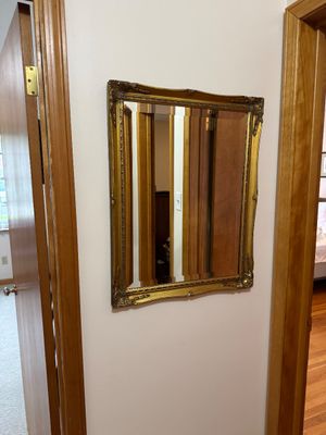 Sale Photo Thumbnail #16: Vintage wall mirror featuring a beveled glass pane and an ornate, gilded frame with decorative corner flourishes.