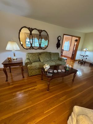Sale Photo Thumbnail #4: Traditional living room set featuring a green patterned sofa, a dark wood coffee table, a matching end table with a lamp, and a large ornate triple-oval wall mirror.