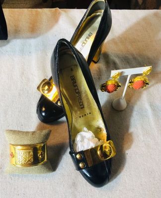 Bruno Frisoni black patent leather pumps with gold-tone hardware, shown alongside a  PROVOST gold-tone cuff bracelet and a pair of...