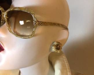 BOTTEGA VENETA oversized sunglasses with textured gold-tone frames and gradient lenses, shown alongside a matching square clip-on...