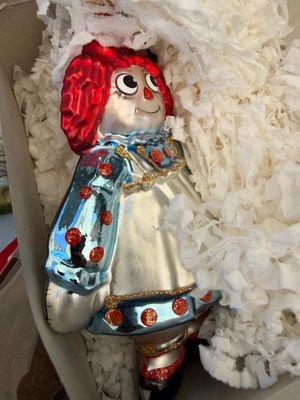 Sale Photo Thumbnail #68: Vintage Raggedy Ann blown glass Christmas ornament, featuring glitter accents and vibrant red hair, nestled in its original packaging.