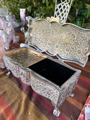 Sale Photo Thumbnail #45: Vintage silver-plated footed jewelry and music box featuring intricate floral filigree engraving and a black velvet-lined compartment.