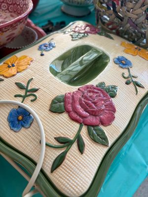 Sale Photo Thumbnail #22: Vintage ceramic casserole dish lid featuring a textured basketweave pattern and embossed floral designs, including a prominent pink rose, yellow flowers, and blue blossoms.