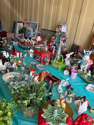 Sale Photo Thumbnail #14: Assortment of holiday and seasonal decorations, including Easter rabbit figurines, ceramic roosters, and Christmas items displayed on a teal tablecloth.