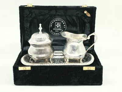 International Silver Co. silver-plated creamer and sugar set with matching tray, presented in its original black velvet-lined display box.
