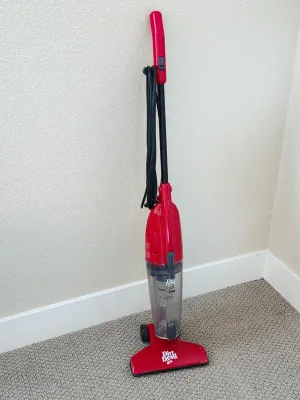 Dirt Devil Swivel Stick corded vacuum cleaner in red, featuring a bagless design and a wrapped power cord.