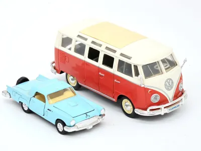 Vintage die-cast toy vehicles, featuring a red and white Volkswagen Microbus and a light blue Ford Thunderbird.