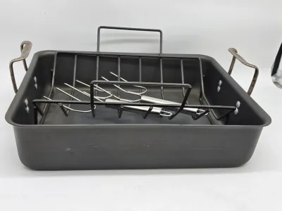 Calphalon hard-anodized aluminum roasting pan with a removable wire rack and a pair of turkey lifter forks.
