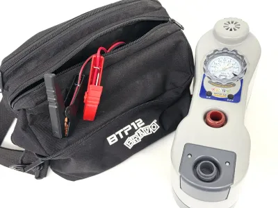 Bravo BTP12 high-pressure 12V electric pump with integrated pressure gauge, battery clamps, and original black carrying bag.