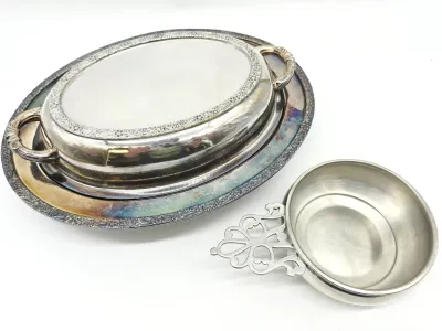 Vintage silver-plated oval covered serving dish with matching underplate, showing some tarnish, alongside a small pewter porringer with a...