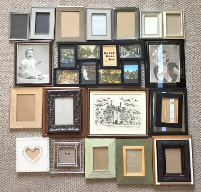 Assorted collection of picture frames in various sizes, materials, and styles, including wood, metal, and plastic, some containing...