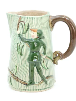 Vintage ceramic pitcher featuring a relief design of Robin Hood on a textured green background with a brown handle.