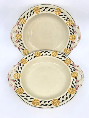 Pair of vintage hand-painted ceramic serving bowls with handles, featuring a yellow floral and black leaf border pattern.